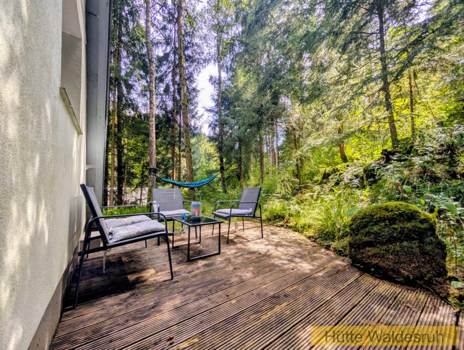 Blick ins Grüne Sitzplatz auf der Holzterrasse mit Blick auf die umliegenden Bäume